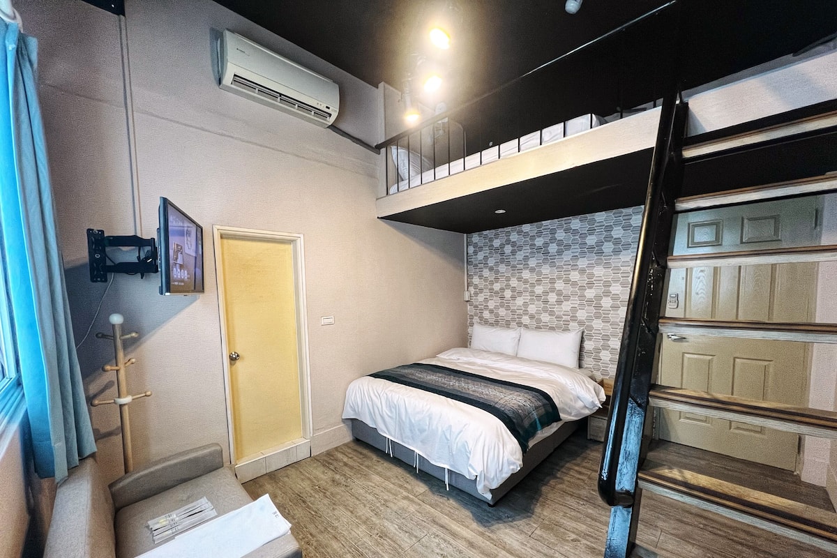 A compact room with a bunk bed, a small desk, and a wall-mounted air conditioner.