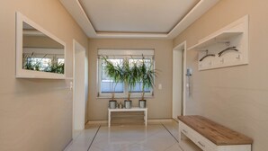 A hallway with a white bench, a wooden bench, and a mirror on the left. - Villa Ost - Apartment Simone - high-quality designed domicile (Zinnowitz)