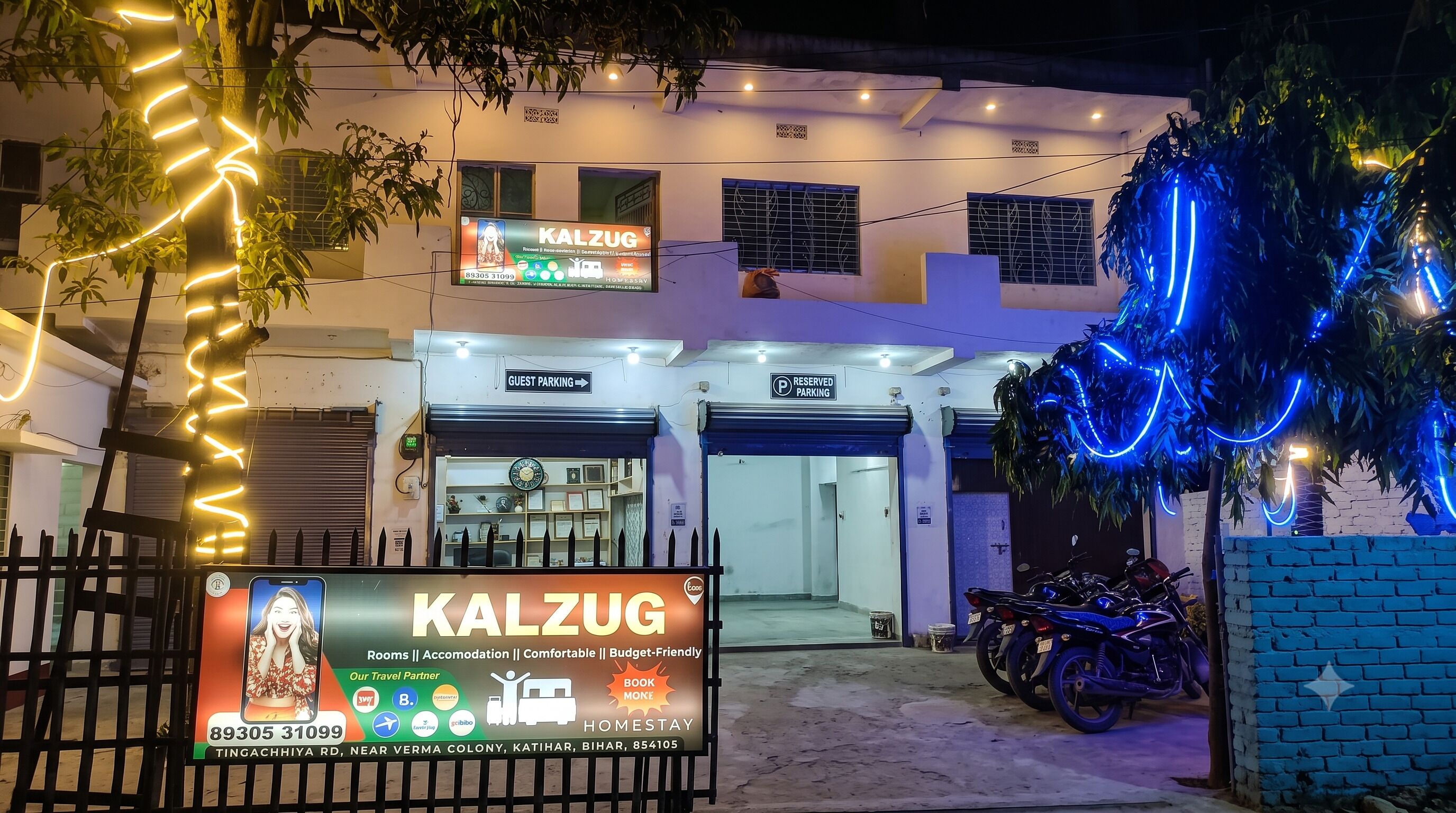 Un edificio con un cartel que indica 'KALZUG', estacionamiento para huéspedes y habitaciones.