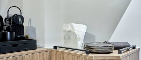A modern kitchen with a wooden countertop, a marble sink, and a black speaker.