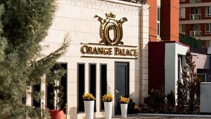 The exterior of Orange Palace hotel with a prominent entrance, large potted plants, and a patterned pavement. - ORANGE PALACE ESKİŞEHİR (Eskisehir)