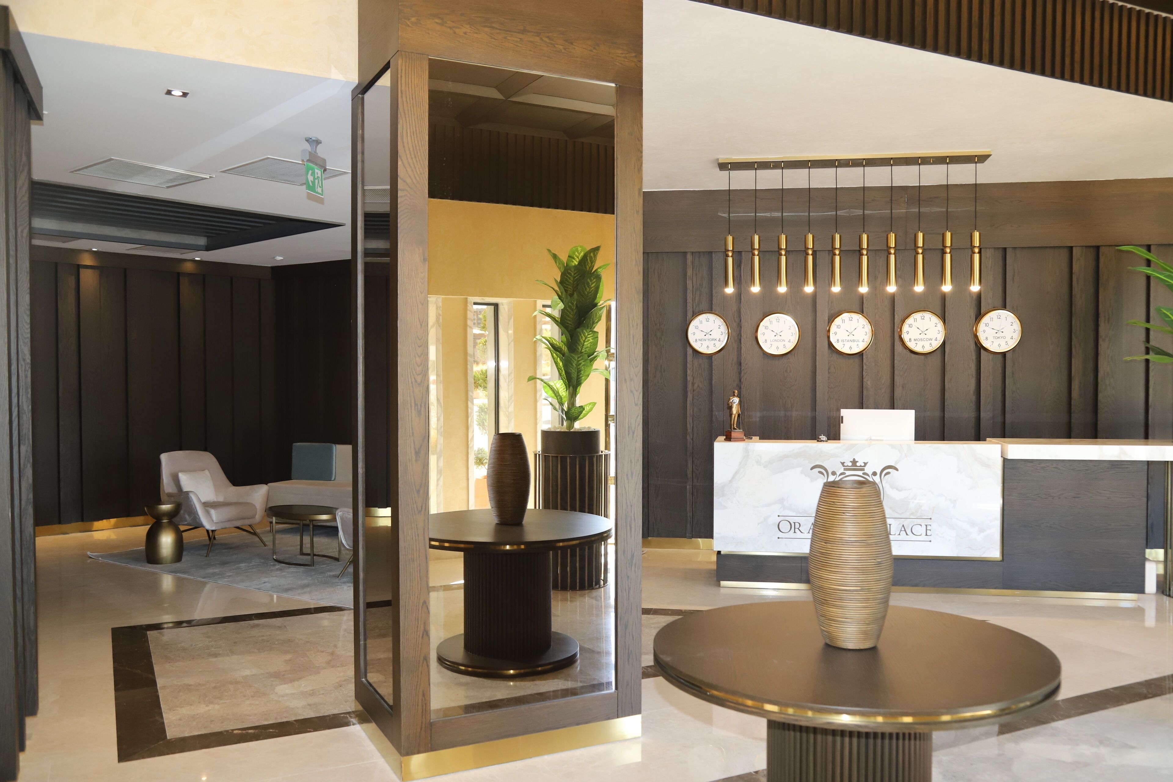 A modern reception area with a marble counter, a large vase, and a hanging light fixture.
