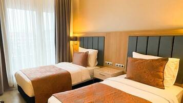 Deluxe Twin Room | Minibar, in-room safe, laptop workspace, blackout drapes