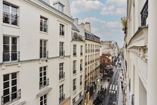 A narrow street flanked by multi-story buildings with balconies and windows. - Charming Apartment Center of Paris/montorgueil (Paris)