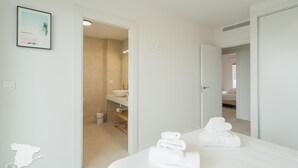 Une chambre d’hôtel avec un lit, une salle de bain et un couloir.