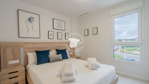 A modern hotel room with a large bed, a wooden headboard, and a view of the road through a large window. - CostaBlancaDreams - Silver Tower 2A in Calpe (Calpe / Calp)
