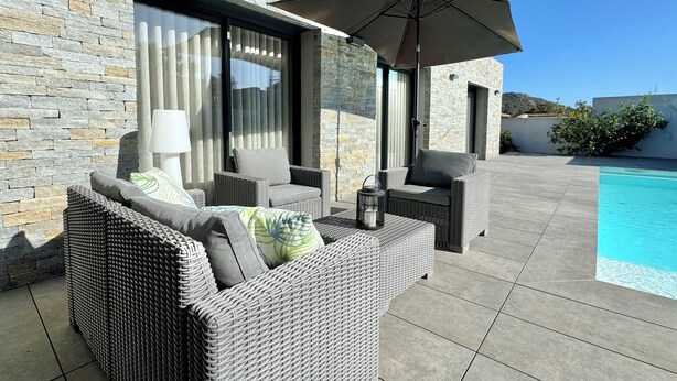 A modern outdoor seating area with wicker furniture and a pool. - Villa Porto-Vecchio with swimming pool 8 persons (Lecci)