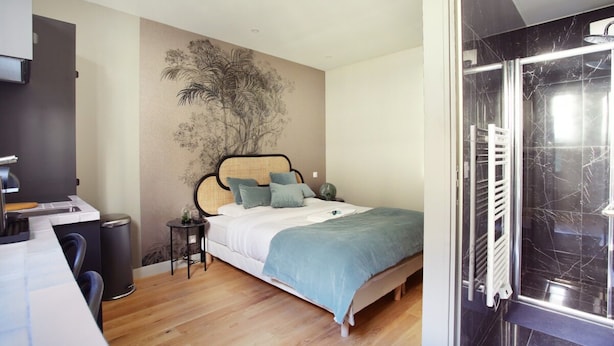 Una camera da letto con un letto, una scrivania e una sedia. Si nota un muro con un affresco, un termosifone e una porta che dà su un bagno.