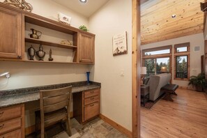 Una cocina con armarios de madera, encimera de granito y comedor con banco y mesa.