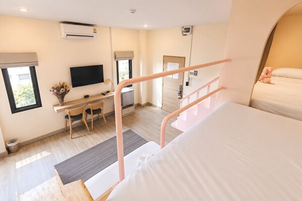 Una habitación de hotel con cama, escritorio con silla, televisor y ventana con vista.