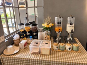 A breakfast buffet with various food items and drink dispensers.