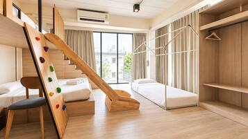 Quarto de hotel moderno com uma parede de escalada de madeira, uma cama, um sofá e uma janela grande com vista para a cidade.