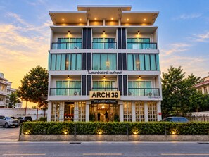 A multi-story hotel with a modern design, featuring balconies and large windows. - Mandalar Arch 39 Hotel (Chiang Mai)