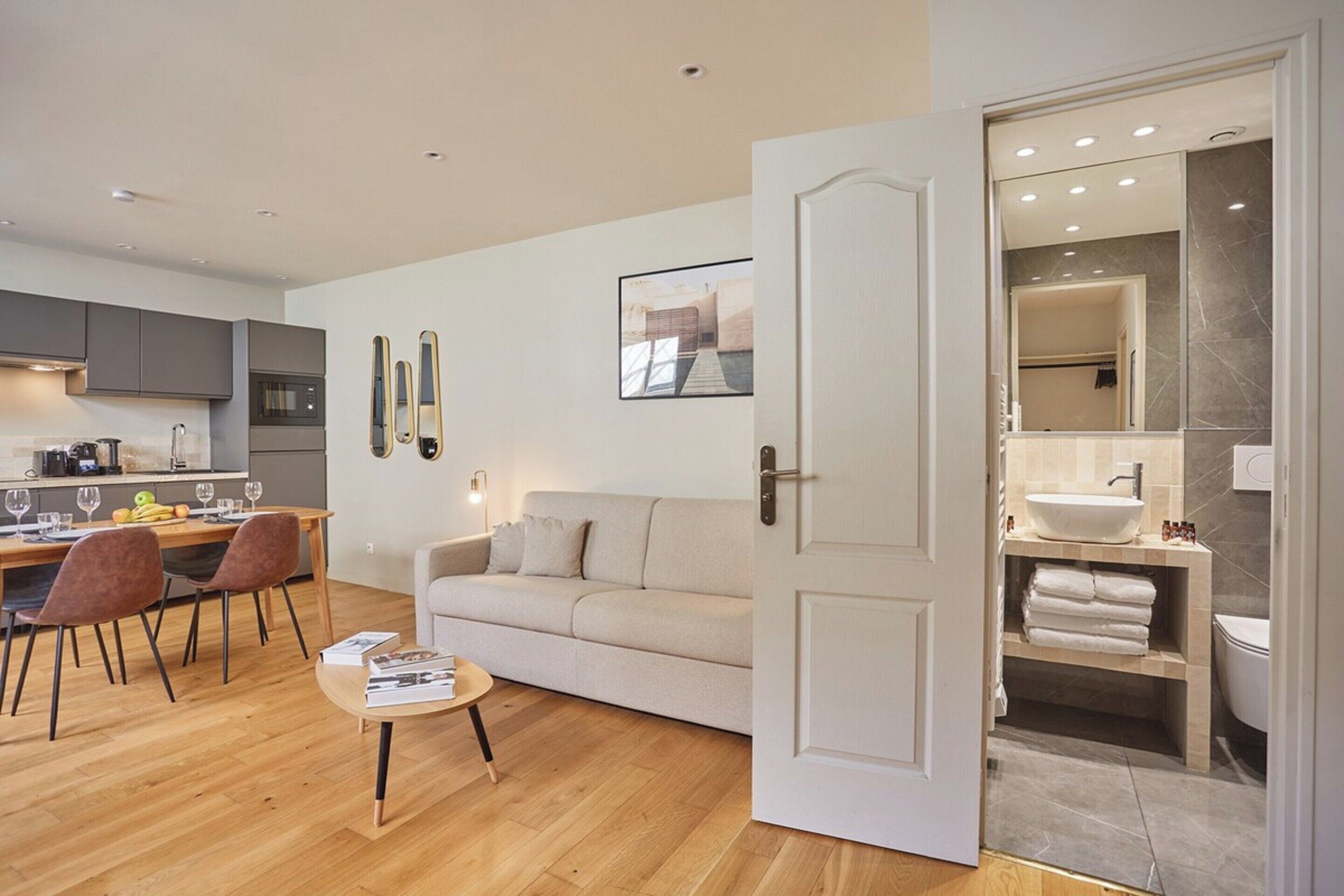 A modern apartment with a kitchen, dining area, and a bathroom.