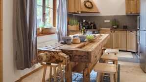 Een rustieke keuken met houten kasten, een houten tafel en krukken.