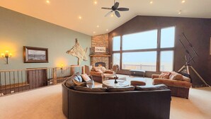 Amplia sala de estar con un sofá modular grande, una chimenea y un balcón con vistas.