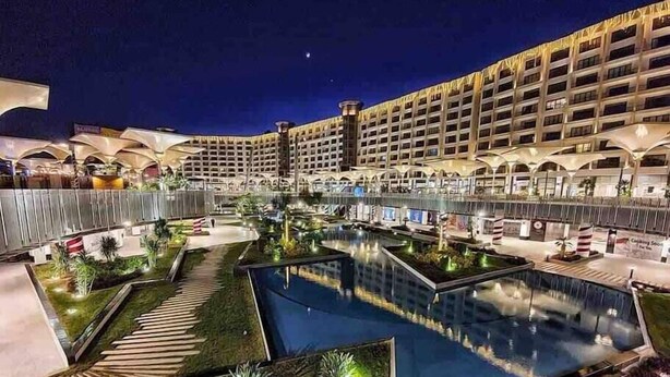 Un hôtel doté de plusieurs piscines, d’un grand parking et d’un espace extérieur bien éclairé.