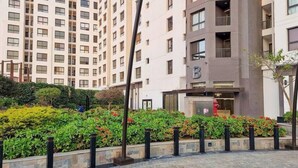 Un immeuble résidentiel à plusieurs étages, doté d’une architecture moderne, de balcons et de grandes fenêtres.