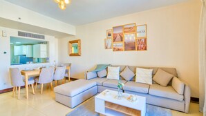 Een moderne woonkamer met een bank, salontafel, eettafel en stoelen.