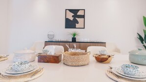 A dining area with a table set for four, including plates, cutlery, and a centerpiece. - The Seven Six Near Waterway 5A - 3, THE SEVEN SIX near WATERWAY 5A MALL By ELEGANT (New Cairo City)