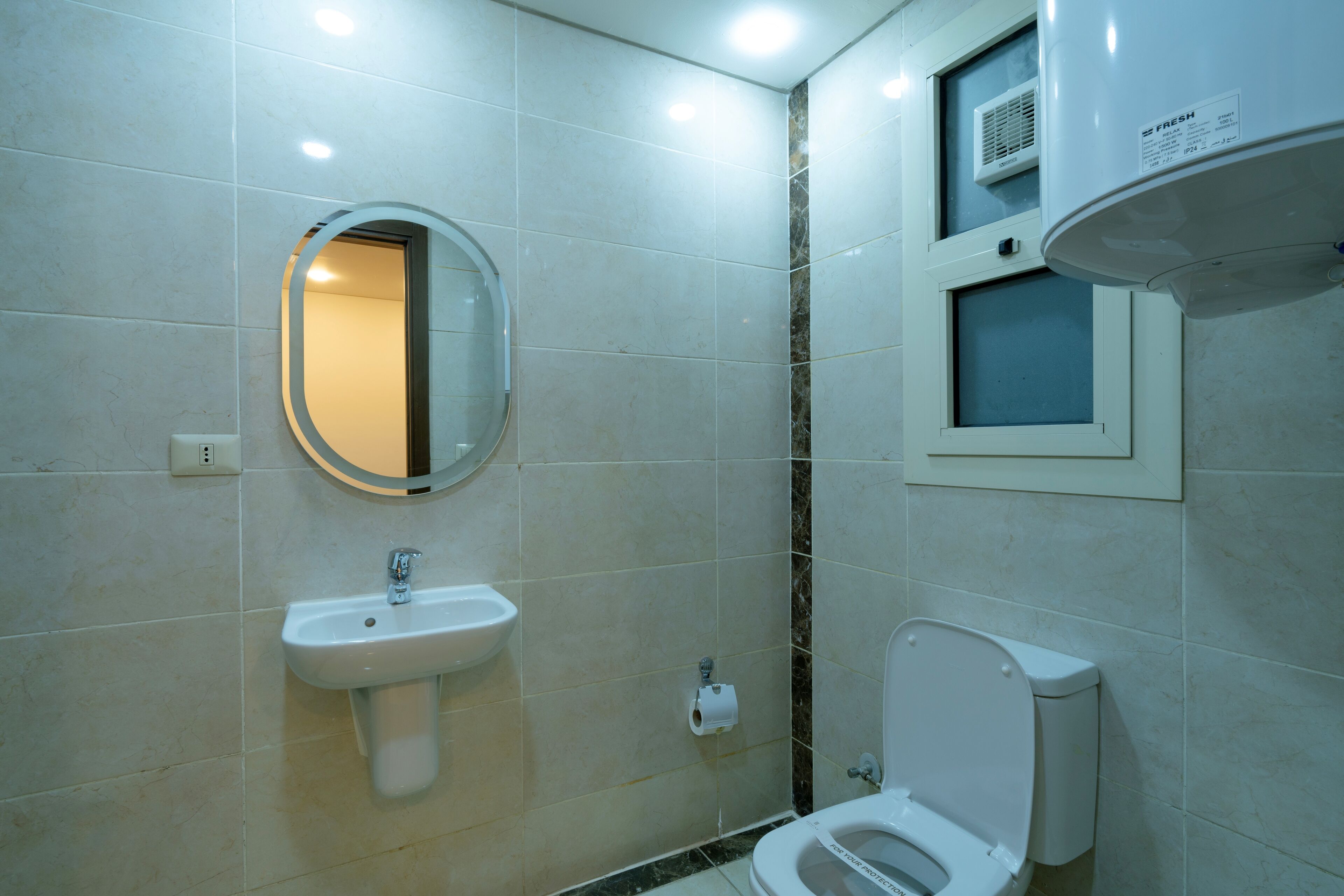 Un bagno moderno con lavandino, WC e specchio.