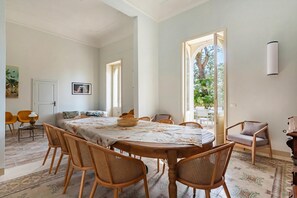 A dining area with a round table, wooden chairs, and a patterned tablecloth. - Vallone Apartments (Galatina)