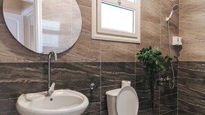 Baño con lavamanos, inodoro y ducha.