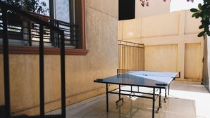 A ping pong table in an indoor space with a tiled floor and a beige wall. - The Seven Six Near Waterway 5A - 12, THE SEVEN SIX near WATERWAY 5A MALL By ELEGANT (New Cairo City)