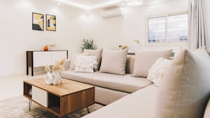 A modern living room with a beige sofa, a wooden coffee table, and a sideboard. - VIOLA Near Waterway - 11, VIOLA New Studio - Higher Floor (New Cairo City)
