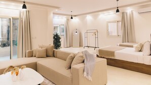A modern living room with a beige sofa, a white coffee table, and a hanging light fixture. - VIOLA Near Waterway - 21, VIOLA New Studio - Higher Floor (New Cairo City)