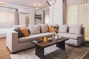 A modern living room with a sofa set, a coffee table, and a hanging light fixture. - VIOLA Near Waterway  - 22, VIOLA New Studio - Higher Floor (New Cairo City)