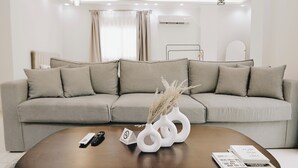 Ein modernes Wohnzimmer mit einem grauen Sofa, einem Holztisch und dekorativen Vasen.