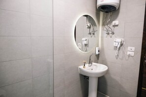 A bathroom with a white sink, a mirror, and a hairdryer mounted on the wall. - VIOLA Near Waterway  - 22, VIOLA New Studio - Higher Floor (New Cairo City)