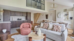 A spacious loft with a kitchen, dining area, and a cozy seating area with a sofa and armchairs. - Amazing Apartment Le Marais Center of Paris (Paris)