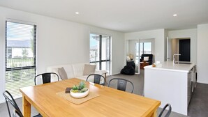 A modern apartment with a dining area, kitchen, and living space. - Woodend Getaway, Modern 3-Bedroom, 2-Bathroom Home,  (Woodend)