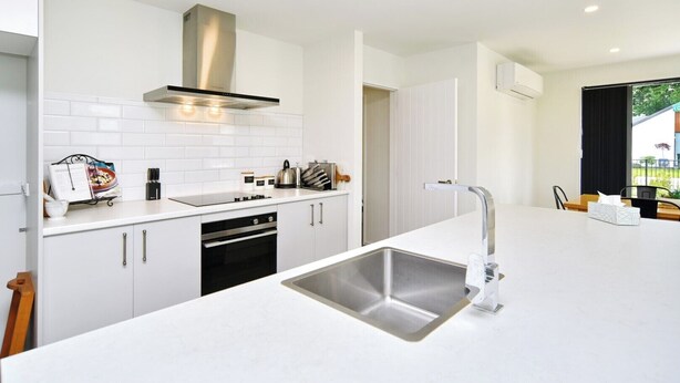 A modern kitchen with white cabinetry, a stainless steel sink, and a built-in oven. - Woodend Getaway, Modern 3-Bedroom, 2-Bathroom Home,  (Woodend)