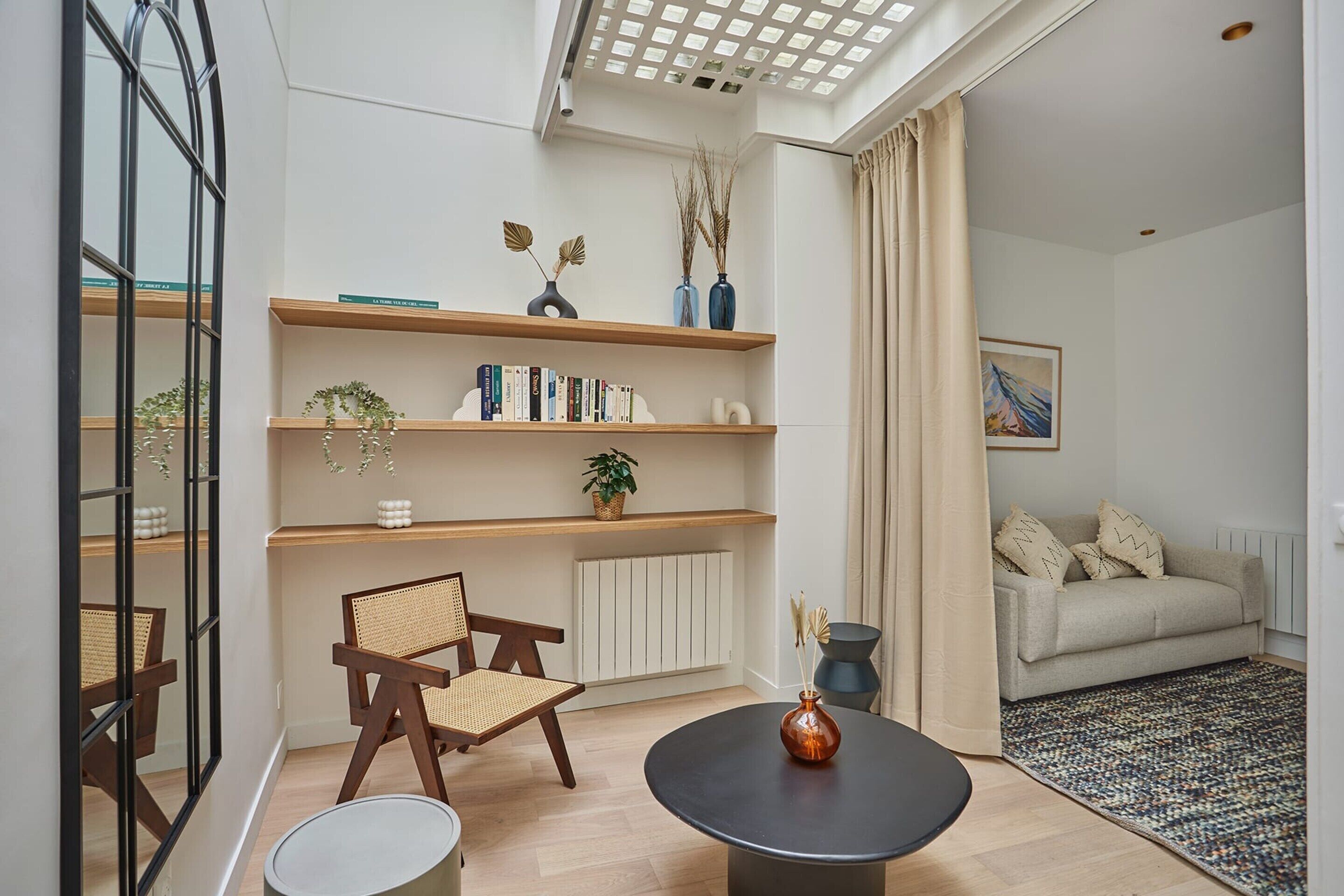Ein modernes Wohnzimmer mit einer Couch, einem runden Tisch und einem Bücherregal.
