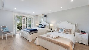 A bedroom with two beds, a chair, a nightstand, and a window with a view of greenery. - Harbourfront Haven –4BR Retreat with Stunning Views of Sydney’s Iconic La... (Cremorne Point)