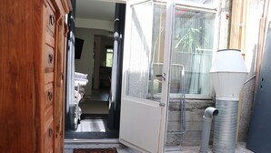 A narrow entrance with a wooden door, a metal gate, and a concrete floor. - Antique Rentals (Reykjavik)