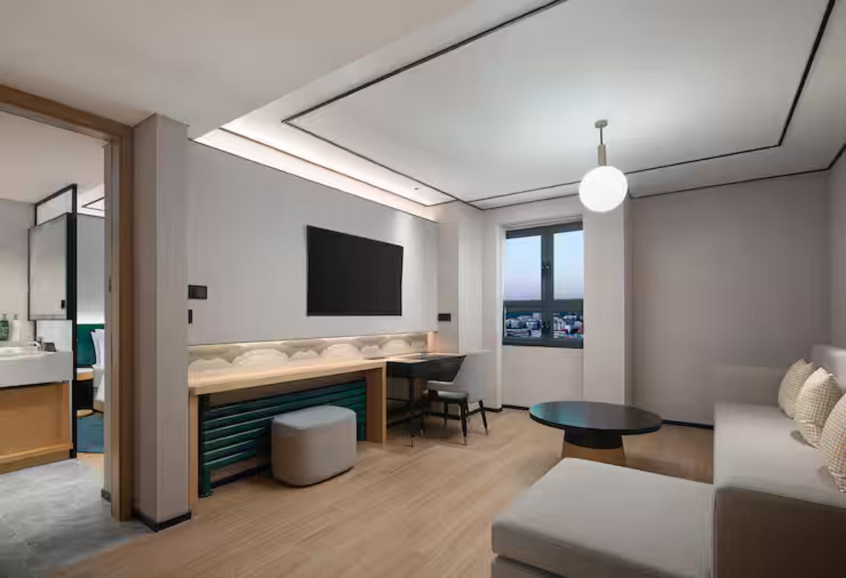 Une chambre d’hôtel moderne dotée d’une kitchenette, d’une grande fenêtre et d’un coin salon.