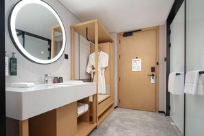 A modern bathroom with a wooden vanity, a large mirror, and a wooden door. - Hilton Garden Inn Chengde Mountain Resort (Chengde)