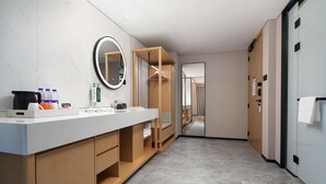 A modern bathroom with a large mirror, wooden vanity, and a walk-in closet. - Hilton Garden Inn Chengde Mountain Resort (Chengde)