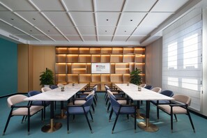 A conference room with a long table, chairs, and a wall with illuminated panels. - Hilton Garden Inn Chengde Mountain Resort (Chengde)