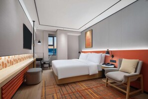 A hotel room with a bed, a desk, a chair, and a window with a view. - Hilton Garden Inn Chengde Mountain Resort (Chengde)