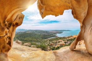 A natural rock formation with a view of a coastal landscape. - Sandy Bear Guesthouse (Palau)