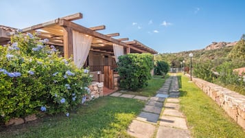 Un espacio exterior cubierto con un sendero de piedra que conduce a un edificio.