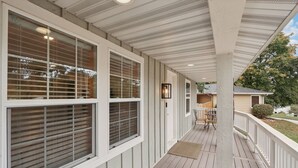 A covered porch with white railings and a wooden deck. - Hines Terrace Retreat - Hot Tub & Firepit (Wisconsin Dells)