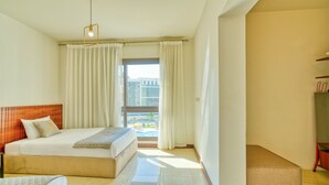 Une chambre d’hôtel avec un lit, un canapé, une petite table et une vue sur l’extérieur.
