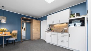 Una cocina moderna con armarios blancos, encimera de madera y horno integrado.