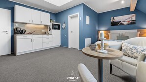 Una habitación moderna con tragaluz, una cama, una mesita y un pequeño espacio de cocina.